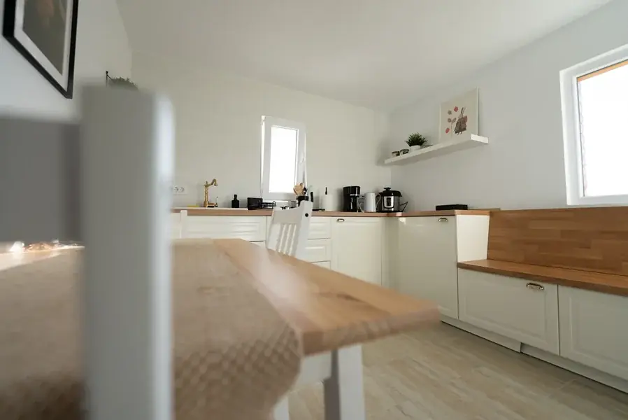 The kitchen, with white cabinets, wooden worktops and appliances