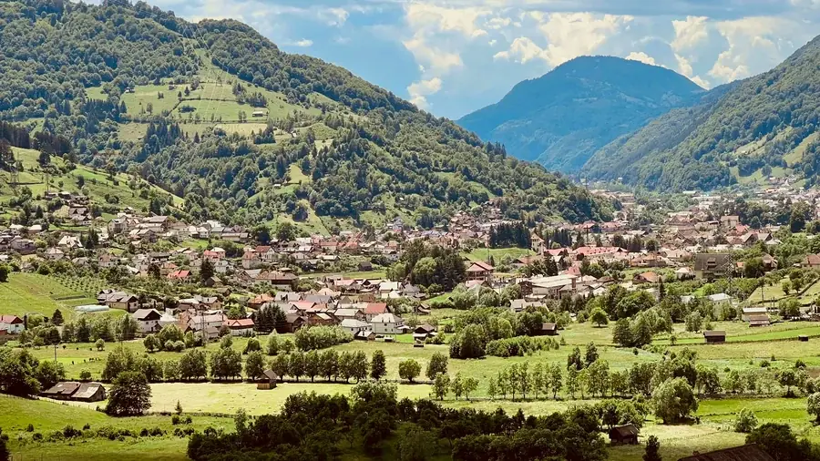 Rucăr seen from above in summer, between green meadows and mountains