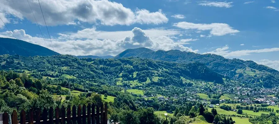 A summer view over the fence to the green hills and the village below