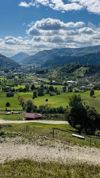 The house's 9,000 m² garden, with a wooden fence and a view to the green valley and mountains