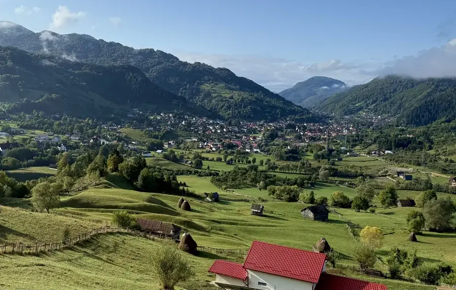 Summer beside the house: meadows with haystacks, the village below and the mountains