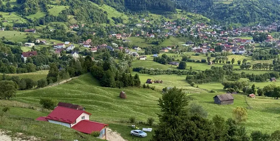 The red-roofed house on the hillside above Rucăr village in summer